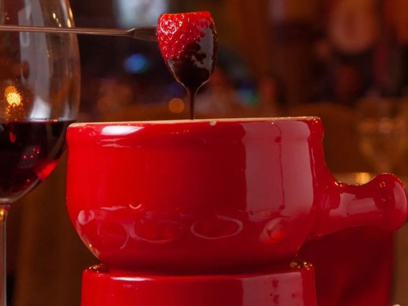 Morango mergulhado no fondue de chocolate