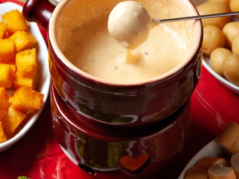 Pão mergulhado no fondue de queijo